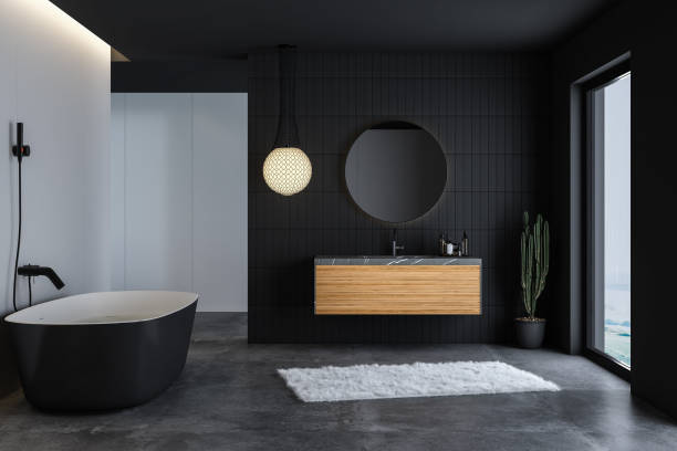 Modern bathroom interior with concrete floor, black bathtub, stock photo