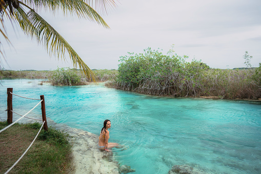 Young woman swimming in Bacalar Lagoon in Mexico