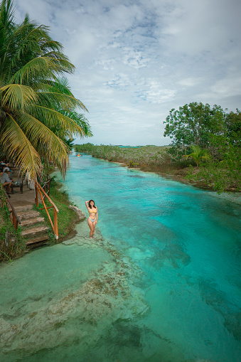Young woman swimming in Bacalar Lagoon in Mexico