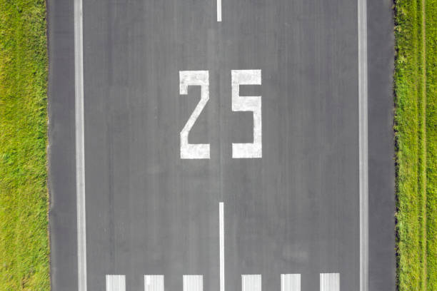 Aerial view of an airport runway with the direction marking 25 (250 degrees).