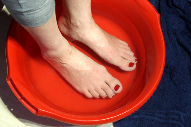 istock Women's feet are heated in warm water. 1393009834