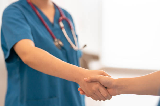 istock unrecognizable doctor shaking hand with patient in low angle view. 1393014372