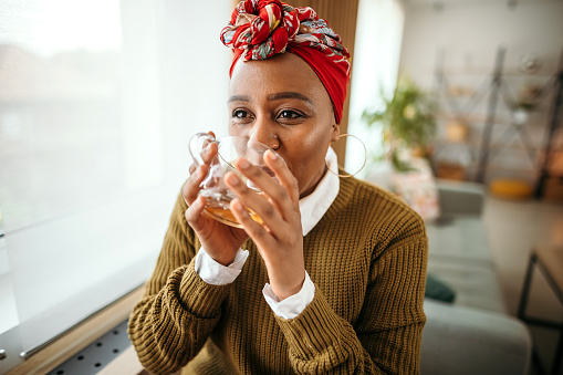 Beautiful black girl drinks tea at home