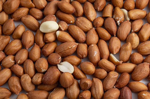 Texture with nutritious and fresh raw peanuts, shelled and still with the skin