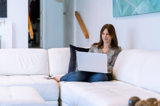 istock Mature latin woman using computer at home 1393019605