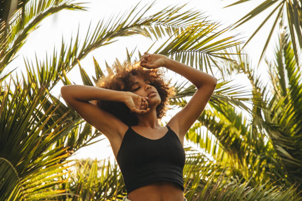 istock Pretty young afro woman among palm trees 1393019646