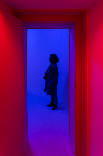Sığınakta bulunan mavi ve kırmızı ışıklı odalar. bu odalar da insan psikolojisi üzerine etki edecek renkler kullanılmakta ve sesler dinletilmektedir. Sığınağı gezen ziyaretçi kadın full frame makine ile çekilmiştir.