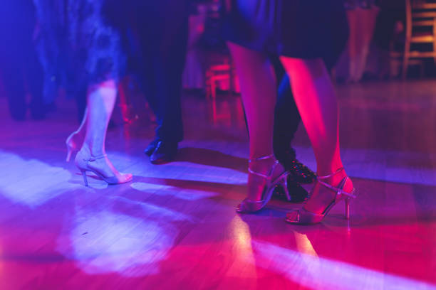 한 쌍의 춤추는 신발, 볼룸에서 전통적인 라틴어 아르헨티나 댄스 밀롱가 춤추는 커플, 탱고 살사 바차타 키잠바 레슨, 나무 바닥에서의 축제, 보라색, 빨간색 및 보라색 조명 - polka dancing 뉴스 사진 이미지