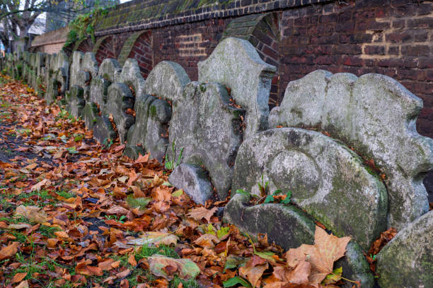 Ancient overgrown tombstones and graves at churchyard garden on autumn morning. stock photo