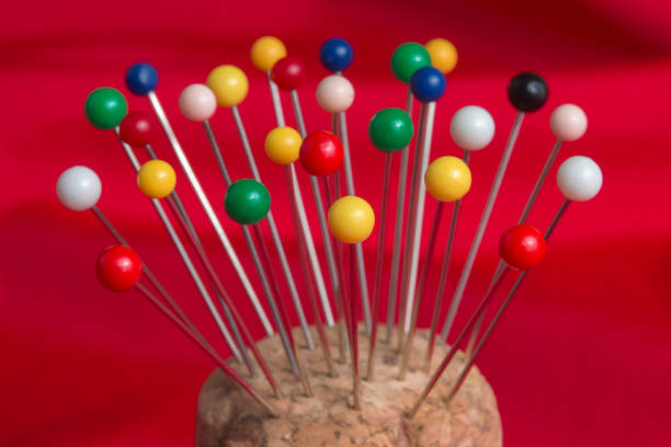 istock Sewing pins in pincushion against red fabric 1393031650