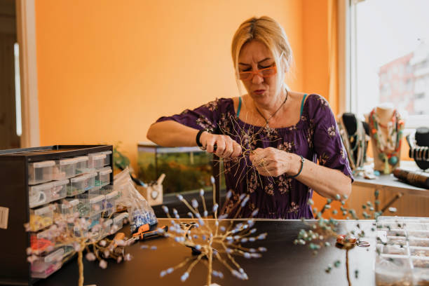 istock Senior woman making small wire tree, home decoration 1393031704