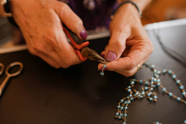 istock Senior woman making hand made necklaces 1393031943
