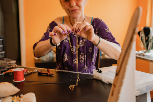 istock Senior woman, making hand made necklaces 1393031953
