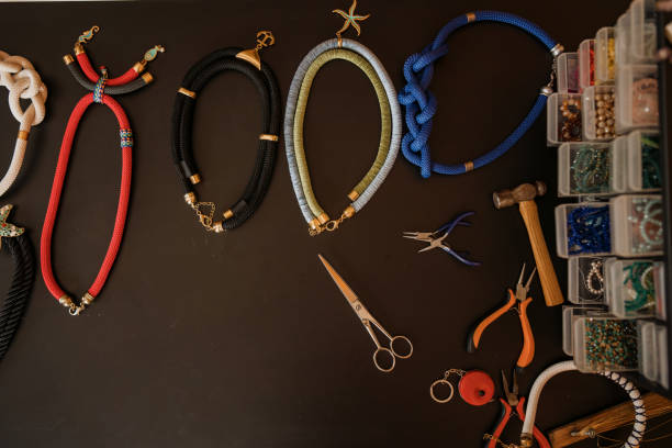 Colorful necklaces on wooden table. Jewelry, Wire, Workshop