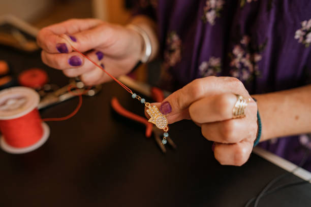 istock Woman making hand made bracelet 1393032475