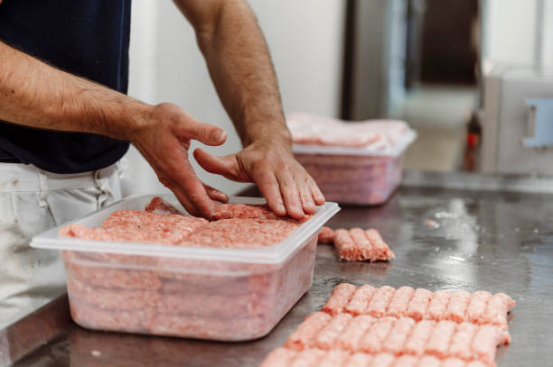 istock Butchers hands packaging minced meat sausages 1393041552