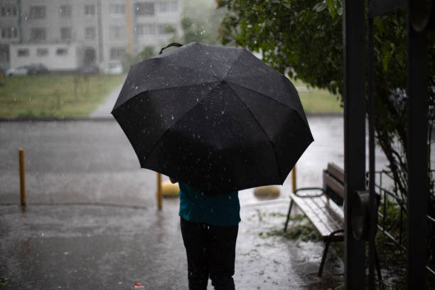 istock A man with an umbrella under a downpour. 1393042692