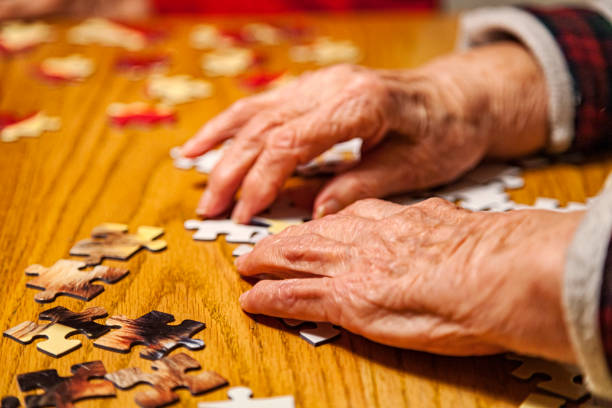 istock Elderly Woman's Hands Working on Jigsaw Puzzle 1393044360