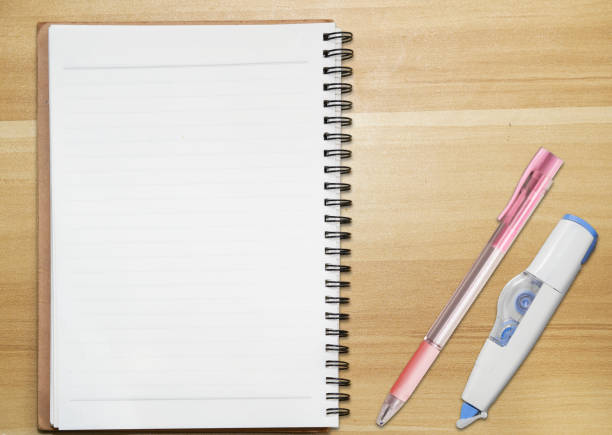 spiral notebook isolated on table with pen and correction tape