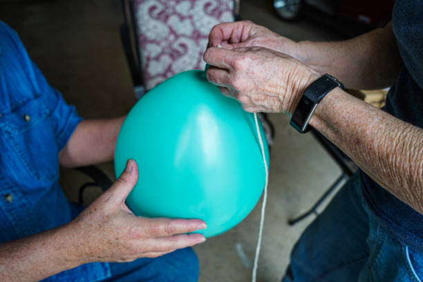 istock Senior Adults Tie Helium Balloons, close-up 1393048856