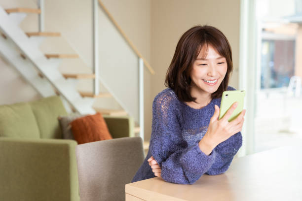 スマートフォンを使用して魅力的なアジアの女性 - スマホ 日本人 ストックフォトと画像