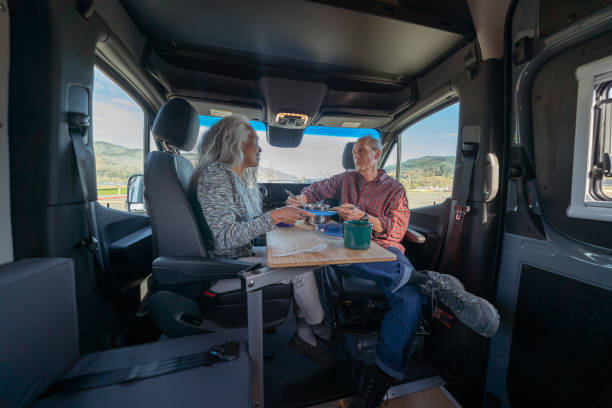 Retired couple eating meal inside luxurious customized camper van