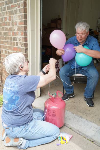istock Senior Adults Inflate Helium Balloons 1393060083