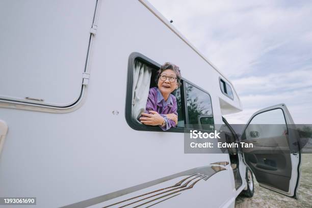Happy Asian Chinese Senior Woman Looking Away From Motor Home Window Stock Photo - Download Image Now