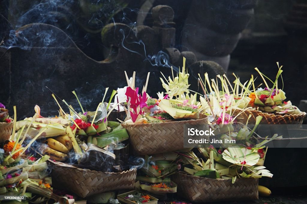 Temple offerings at Pura Tirta Empul (Hindu holy water temple) near Tampaksiring; Bali, Indonesia Hindu offerings of flowers and incense sticks at the temple of holy water (Pura Tirta Empul) near Tampaksiring, Bali Pura Tirta Empul Temple Stock Photo