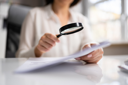 Auditor Doing Tax Fraud Investigation Using Magnifying Glass