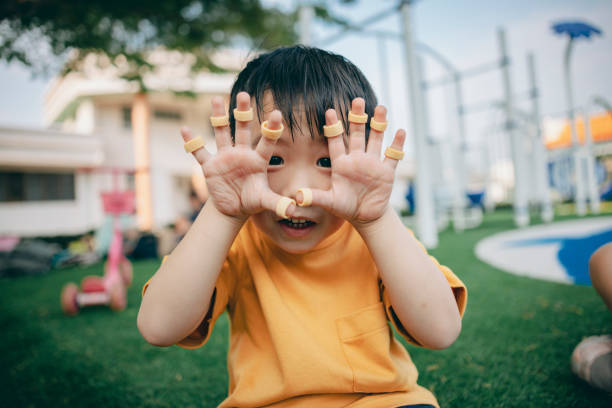 Child's arm holding up fingers on white.