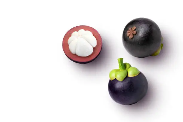 Mangosteen fruit with cut in half sliced isolated on white background. top view. Flat lay.