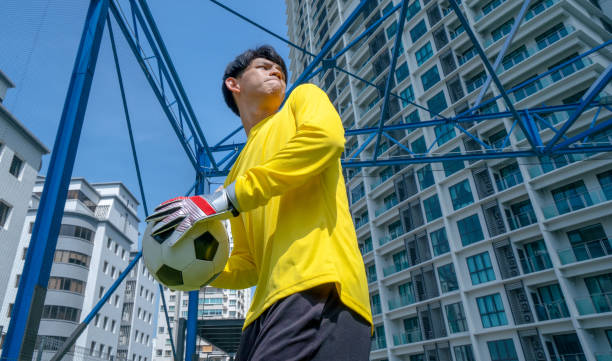 A close-up of a classic black and white soccer ball in a male hand