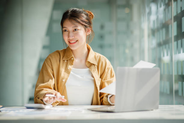 istock Charming Young asian businesswoman sitting on laptop computer 1393067768