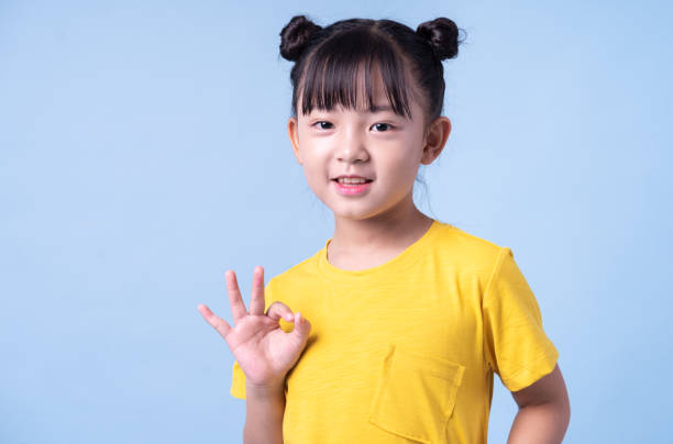 istock Image of Asian child posing on blue background 1393069239