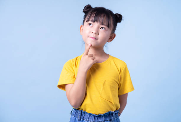 青い背景にポーズをとっているアジアの子供の画像 - 子ども 考える ストックフォトと画像