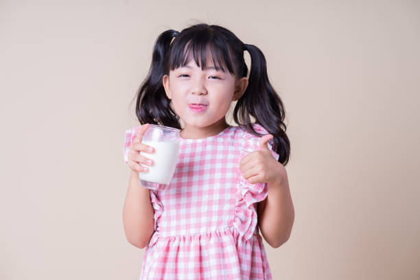 istock Image of Asian child drinking milk on background 1393069431