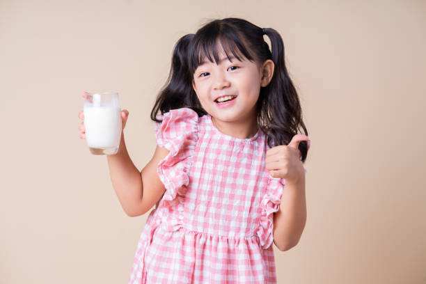 Image of Asian child drinking milk on background