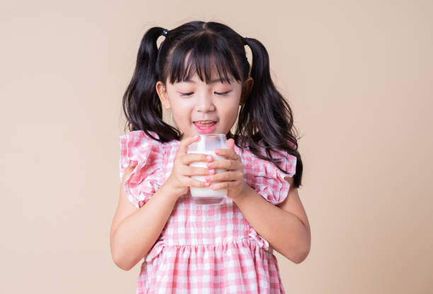 istock Image of Asian child drinking milk on background 1393069435