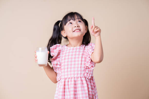 istock Image of Asian child drinking milk on background 1393069445