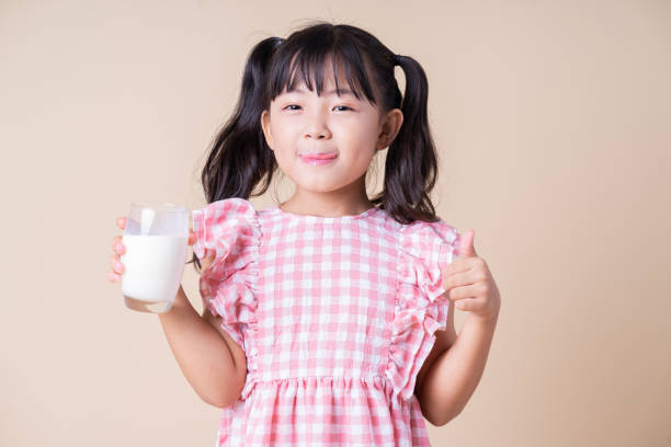 istock Image of Asian child drinking milk on background 1393069446