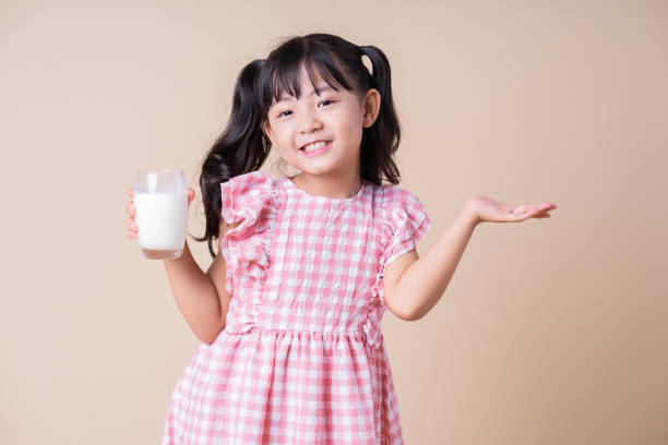 istock Image of Asian child drinking milk on background 1393069447
