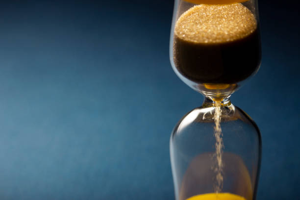 istock Hour Glass with running sand inside, on blue background. Time passing or countdown concept. 1393070309