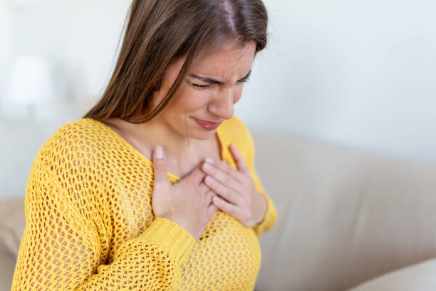 young woman having chestpain,acute pain, possible heart attack.effect of stress and unhealthy lifestyle concept. - chest pain imagens e fotografias de stock