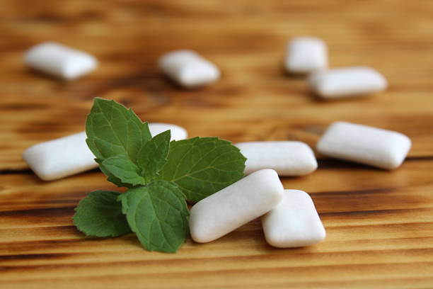 Chewing gum pads with mint lie on a wooden table. Chewing gum pads with mint lie on a wooden table. vitamin rich stock pictures, royalty-free photos & images