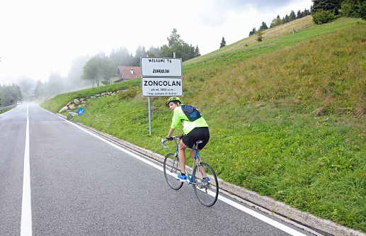 young cyclist riding his racing bike on Monte Zoncolan in northern Italy on a very foggy day