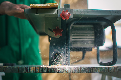 Close-up Of A Machine Tool Called A Table Saw Ejecting Sawdust In A Woodworking Shop. DIY And Craft Concept. Detail