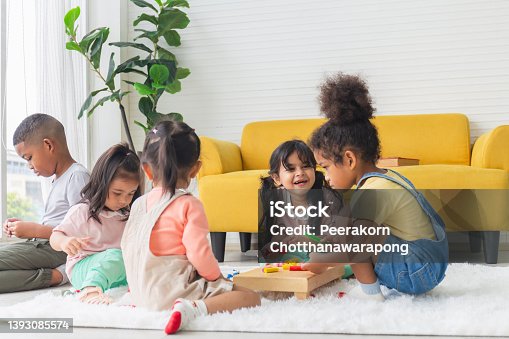 istock Cute little children playing toys in living room, Diverse children enjoying playing with toys 1393085574