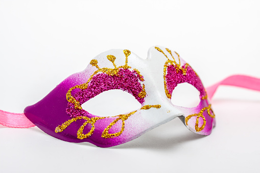 Carnival or mardi gras concept with golden carnival masks and party decorations on yellow background. Top view, flat lay