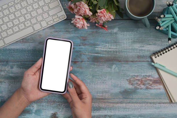 istock Woman hands using smart phone over wooden table. Empty screen for graphic display montage. 1393087721